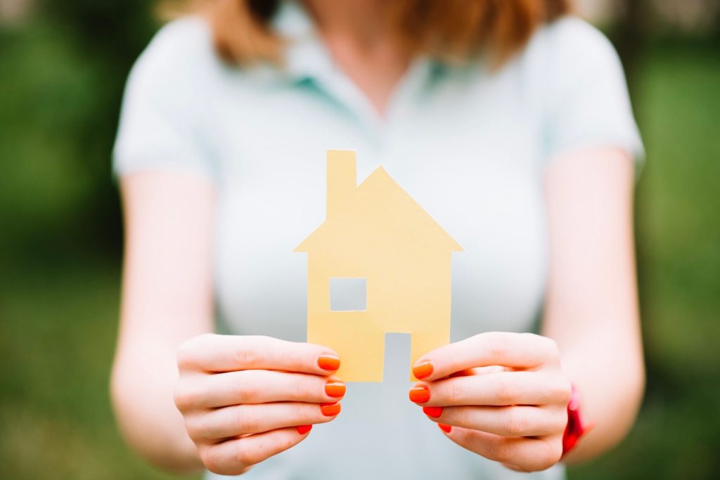 Woman holding an image of a house that will be divided in a divorce